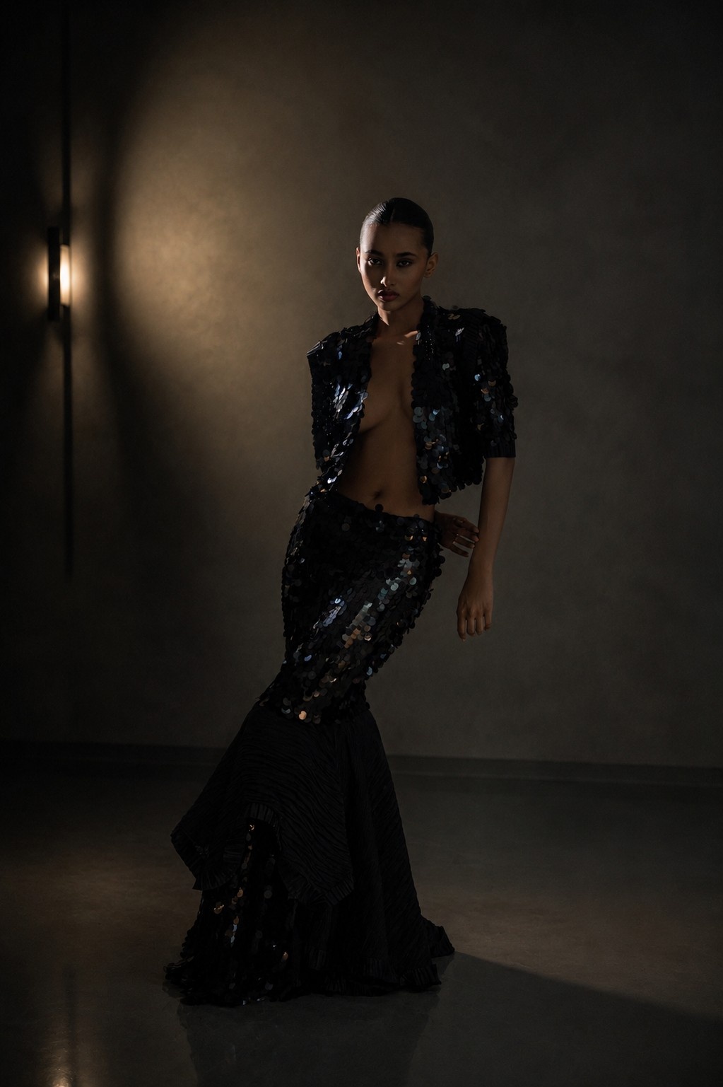 Model wearing Midnight Muse in dramatic low light with glossy reflections